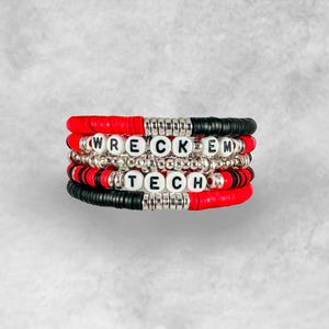May include: Stack of four beaded bracelets in red, black, and silver. The bracelets spell out "WRECK EM TECH" with white letter beads. The bracelets are stacked on top of each other.