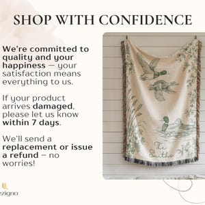 May include: A beige throw blanket with a green duck illustration and fringe trim. The blanket features the text "The Smiths" and the words "Shop with Confidence". The blanket is hanging on a white wooden wall.