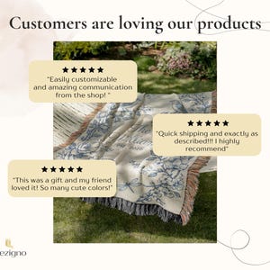 May include: A cream-colored throw blanket with a floral and bird design in blue. The blanket has a fringed edge and the text "The William est. 2026". Customer reviews are displayed above the blanket.