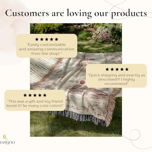 May include: A cream-colored throw blanket with a brown nature-themed design, displayed on green grass. The blanket has a fringed edge and text that reads "Customers are loving our products". Customer reviews are also displayed.
