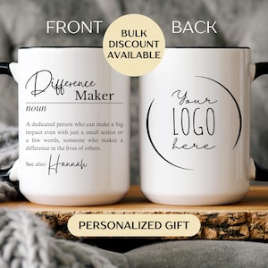 May include: White ceramic mug with a black handle and rim. The front of the mug features the text "Difference Maker" with a definition and the name "Hannah". The back of the mug has a circular design with the text "Your LOGO here".