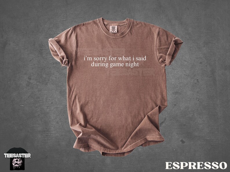 May include: Espresso-colored t-shirt with the text "I'm sorry for what I said during game night" in white. The shirt has a crew neck and short sleeves. The shirt is made of a soft material and is displayed on a gray background.