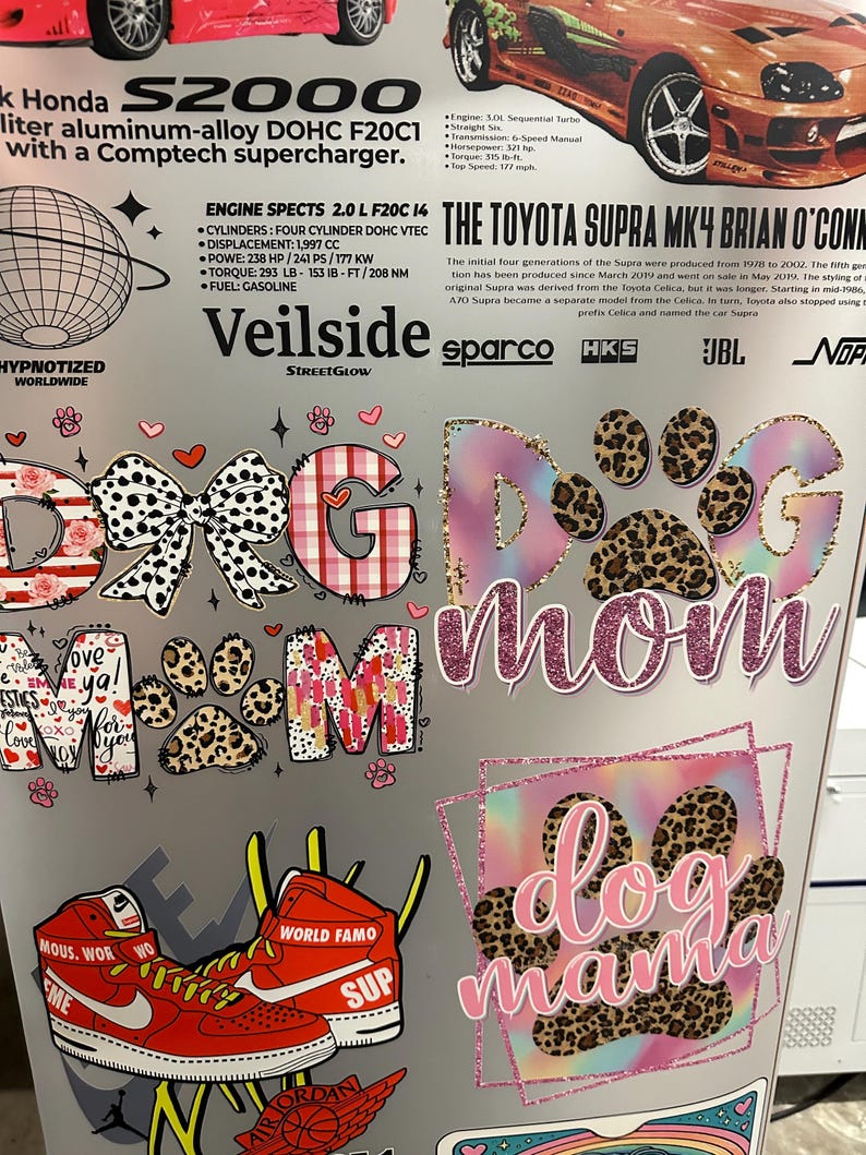 May include: A collage of stickers with the words "Dog Mom" and "Dog Mama" in various fonts and designs. The stickers feature paw prints, bows, hearts, and a pair of red sneakers with the words "World Famo" and "Sup".