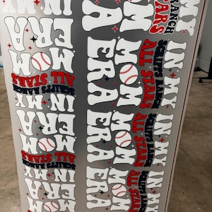 May include: A gray baseball-themed design with the words "In My Mom Era" and "All Stars" in white, red, and navy blue. Baseball graphics are also included. The text "Scripps Ranch" is also present.