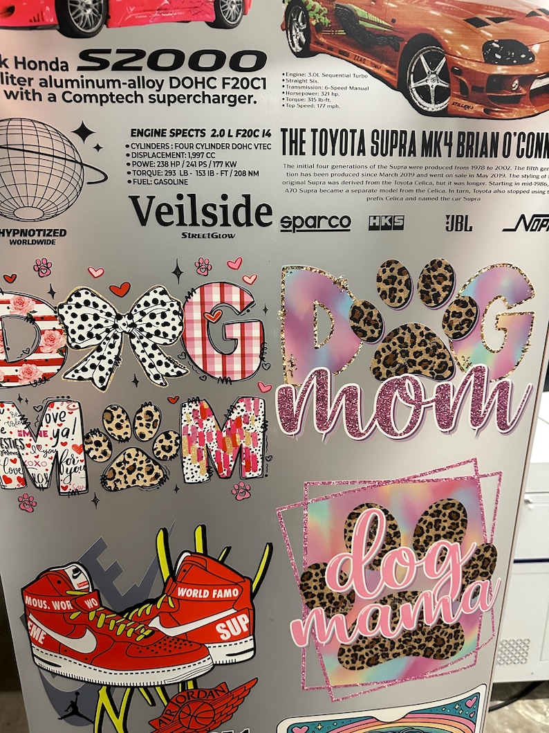 May include: A collage of stickers with car and dog-themed designs. The stickers include the words "Dog Mom" and "Dog Mama" in various fonts and patterns, along with a pair of red sneakers and car specifications.