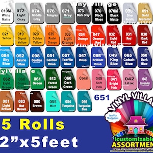 May include: A selection of 5 rolls of 12 inch by 5 foot vinyl in various colors. The vinyl is labeled with numbers and color names. The text "Vinyl Village" is printed in a circle with a rainbow design. The text "Oracal" is printed in white on a black rectangle. The text "5 Rolls" is printed in large white letters. The text "12"x5 feet" is printed in large white letters. The text "Quality Materials" is printed in white on a rainbow background. The text "!customizable! ASSORTMENT" is printed in white on a rainbow background. The text "www.etsy.com/shop/VinylVillage" is printed in white on a black background.