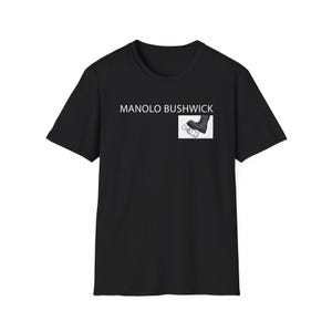 Puede incluir: Camiseta negra con el texto blanco "MANOLO BUSHWICK". Un pequeño gráfico en el pecho derecho muestra una bota y una botella. La camiseta es de cuello redondo.