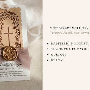 May include: A rectangular white card featuring a laser-cut wooden tag with a cross and floral motif, secured with a mauve chiffon ribbon and a gold wax seal. The card includes the text "Thankful for You" and "PART OF THIS CHAPTER" with a prayer.