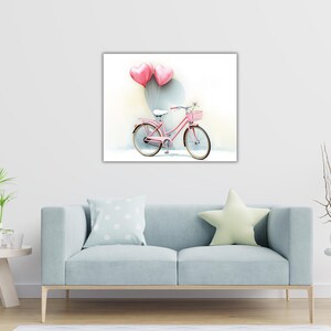 Puede incluir: Una bicicleta rosa con una cesta en el manillar está decorada con globos rosados en forma de corazón. La bicicleta está delante de una pared blanca.