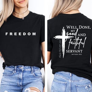 K&ouml;nnte beinhalten: Schwarzes T-Shirt mit dem Wort "FREEDOM" in wei&szlig;en Blockbuchstaben. Auf der R&uuml;ckseite des Shirts befindet sich ein wei&szlig;es Kreuz und der Text "Well Done, My Good and Faithful Servant" mit einem Bibelversverweis.