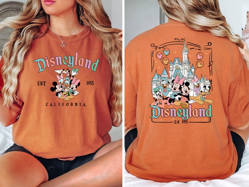 Puede incluir: Camiseta naranja con un gr&aacute;fico de Disneyland con Mickey Mouse, Minnie Mouse, Donald Duck, Goofy y Pluto. El texto de la camiseta dice "Disneyland Est. 1955 California".