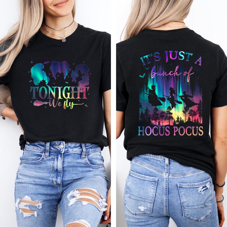 May include: Black t-shirt with a colorful graphic featuring silhouettes of three witches and the text "TONIGHT We fly" on the front. The back of the shirt displays the text "IT'S JUST a bunch of HOCUS POCUS" with witch silhouettes.