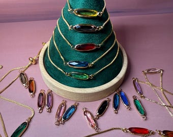 Brass oval charm links with glass stones.