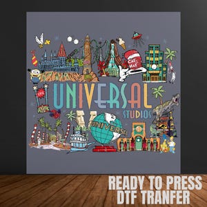 May include: A gray graphic featuring the words "Universal Studios" with colorful illustrations of theme park attractions and characters. The image includes the text "READY TO PRESS DTF TRANFER".