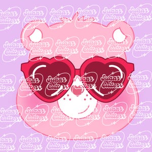 May include: Pink bear face with heart-shaped sunglasses. The bear has a white nose and a small smile. The background is a light purple with a repeating pattern of the words "Sugar Cutters".