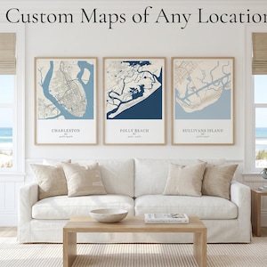 May include: Three framed wall art prints featuring custom maps of Charleston, Folly Beach, and Sullivans Island, SC. Each print displays a blue and white geographic layout with location names and coordinates printed in black text below the map.