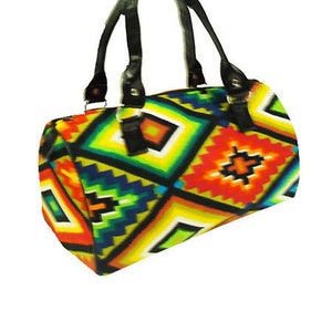 May include: A colorful handbag with a geometric pattern in shades of yellow, green, orange, and blue. The bag has black handles and accents. The design features diamond and zig-zag shapes.