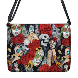 May include: A crossbody bag featuring a Day of the Dead design. The bag's pattern includes sugar skulls, red roses, and women with painted faces. The bag has a black strap and a rectangular shape, perfect for carrying essentials.