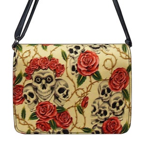 May include: A beige shoulder bag with a black strap. The bag is decorated with a pattern of red roses and white skulls.