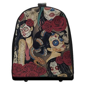 May include: A black travel bag featuring a Day of the Dead design. The artwork includes sugar skull women with red roses, a snake, and a skull on a beige background. The bag has a black trim and a handle.