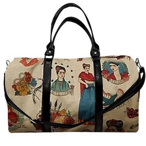 May include: A black leather duffel bag with a cream canvas print featuring colorful illustrations of women and flowers. The bag has a top zipper closure and two black handles.