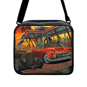 May include: Black messenger bag with a colorful graphic of a retro diner scene. The image features a red classic car, a hot rod, and figures that appear to be zombies. The bag has a black shoulder strap.