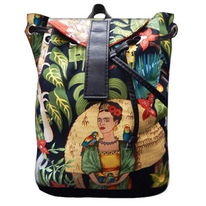 May include: A black drawstring backpack with a colorful print featuring a woman with flowers in her hair, parrots, and tropical plants. The backpack has a black leather strap and a black drawstring.