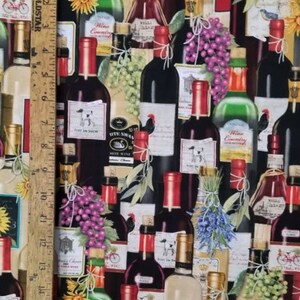May include: A black fabric with a repeating pattern of wine bottles, grapes, and sunflowers. The bottles are various colors and have labels with text such as "White Swan" and "Wine Country".