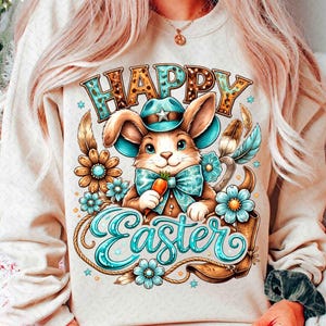 May include: Cream-colored sweatshirt featuring a cartoon bunny wearing a cowboy hat and bow tie, holding a carrot. The words "HAPPY Easter" are displayed in a decorative font, surrounded by flowers and feathers.