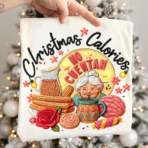 Könnte beinhalten: Bestickter weißer Stoff mit den Worten "Christmas Calories" und einer Illustration einer Frau, einer Tasse und Gebäck. Der Satz "No Cuentan" ist ebenfalls vorhanden. Das Design umfasst eine rote Rose und andere florale Elemente.