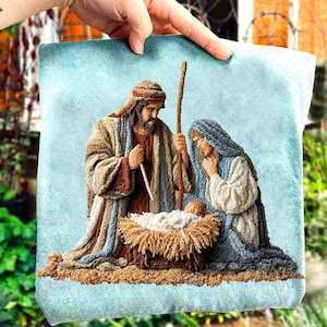 May include: A square, textured tapestry depicting the Nativity scene. Joseph, Mary, and baby Jesus are in the center, with Joseph holding a staff. The color palette includes beige, brown, blue, and white.