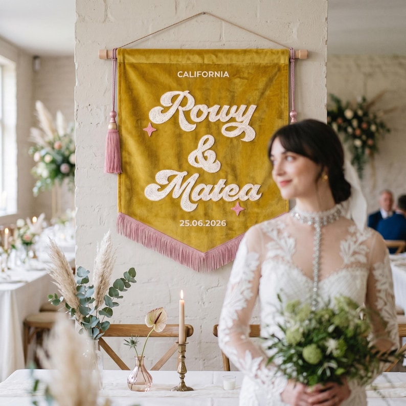 May include: A mustard yellow velvet wall banner featuring the text CALIFORNIA, Rowy & Matea, and 25.06.2026 in white embroidered lettering. The banner is accented with pink star shapes, matching pink tassels on the sides, and a pink fringe bottom.