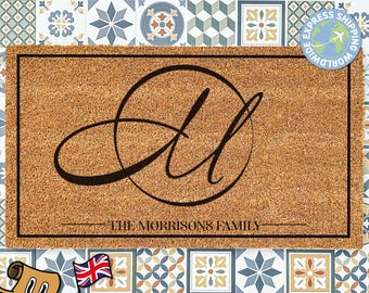 May include: A brown coir doormat with the letters "JL" in a black cursive font inside a circle. The text "THE MORRISONS FAMILY" is printed below the circle.