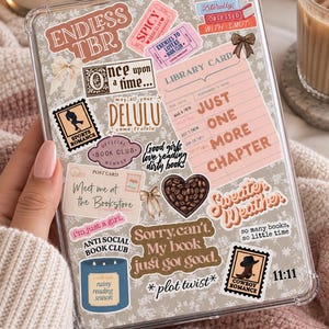 May include: A clear protective tablet case decorated with numerous book-themed stickers, including text like Endless TBR, Just One More Chapter, and Anti Social Book Club, featuring illustrations of bows, a library card, and a coffee bean heart.