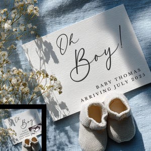 May include: A baby announcement card with the words "Oh Boy!" in elegant script, along with the baby's name and expected arrival date. The card is accompanied by a pair of small, knitted baby booties. The scene is set on a blue fabric, with white flowers.