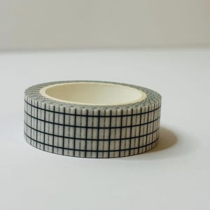 May include: A roll of white washi tape with a black grid pattern.