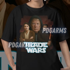 Puede incluir: Camiseta negra con un gráfico de cuatro hombres en una imagen de temática de Star Wars. El texto "Trade Wars" está impreso en azul y blanco en la camiseta.