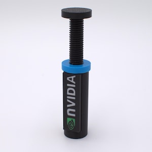 May include: A black and blue NVIDIA branded tool with a screw-like design. The tool has a cylindrical body with the NVIDIA logo and text in white. The top and bottom are black, with a blue ring in the middle.