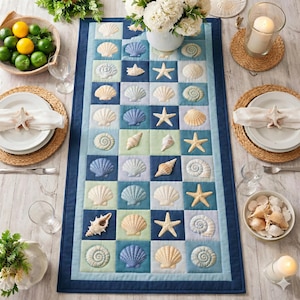 Puede incluir: Un camino de mesa azul y blanco con estampado de conchas marinas. El camino de mesa presenta una cuadrícula de cuadrados con varios diseños de conchas marinas en tonos azules, crema y beige. La mesa está puesta con platos, servilletas y servilleteros en forma de estrella de mar.