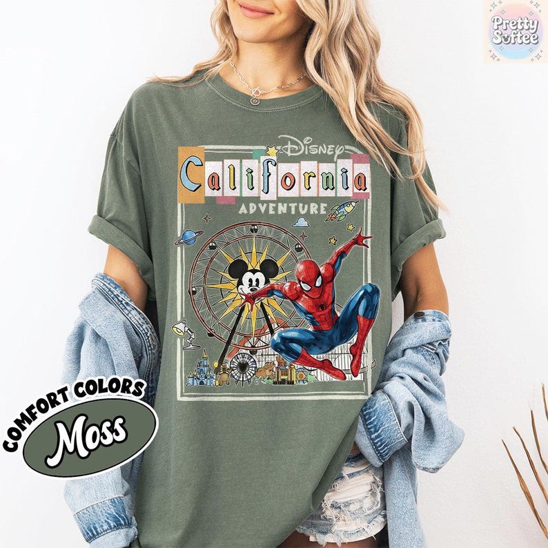 Puede incluir: Camiseta verde musgo con un gr&aacute;fico de una noria, Mickey Mouse y Spider-Man. El texto "Disney California Adventure" se muestra encima del gr&aacute;fico. La camiseta tambi&eacute;n tiene las palabras "Comfort Colors" y "Moss" en la parte inferior izquierda.