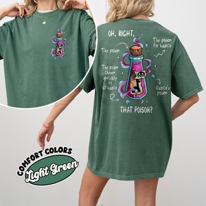 May include: Light green t-shirt with a graphic of a potion bottle and the text "OH, RIGHT, THAT POISON?" on the back. The front of the shirt has a smaller version of the potion bottle graphic. The shirt is made of Comfort Colors material.
