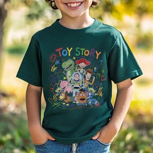 May include: A dark green t-shirt featuring the words "TOY STORY" in colorful letters above a graphic of characters from the animated film. The design includes Woody, Buzz Lightyear, Rex, and other characters.