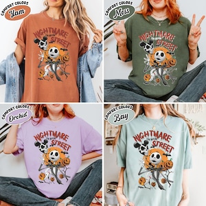 May include: Four t-shirts in different colors: yam, moss, orchid, and bay. Each shirt features a graphic of Jack Skellington from The Nightmare Before Christmas, with the text "Nightmare on Main Street".