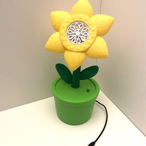 May include: A white ceramic mug with a black handle and the text "But First, Coffee" in a bold, black font. The mug is set against a neutral background, highlighting its simple design.