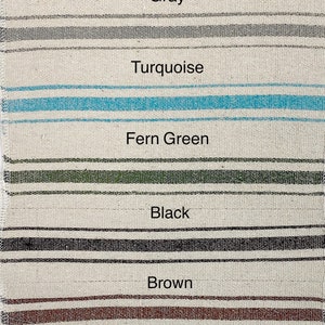 May include: A close-up of a fabric swatch with different colored stripes. The colors are navy, red, gray, turquoise, fern green, black, brown, ochre, and terracotta.