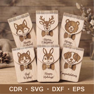 May include: Six rectangular light-colored wooden gift card holders with hinged flaps. Each features a laser-engraved animal face wearing a bow tie, including a fox, deer, bear, cat, rabbit, and dog, with text like Happy Birthday and Merry Christmas.
