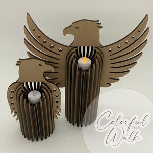 May include: Two brown eagle-shaped candle holders with star accents on the wings. Each holder has a cylindrical base with vertical lines and a small, white candle. The text "Colorful Walk" is visible in the bottom right corner.