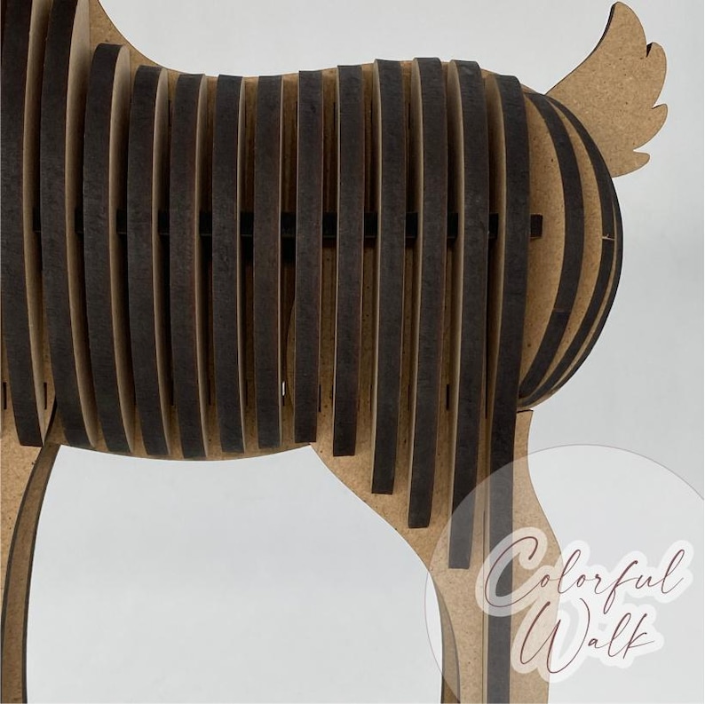 Puede incluir: Escultura de perro de madera con un dise&ntilde;o en capas. El cuerpo del perro est&aacute; hecho de listones verticales de color marr&oacute;n oscuro, creando un efecto rayado. Las patas y la cola son de madera marr&oacute;n claro. La escultura tiene el texto "Colorful Walk".