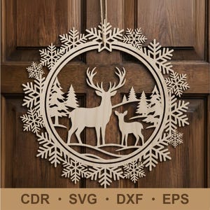Op de afbeelding: Een ronde wandhanger van lichtgekleurd hout met een lasergesneden ontwerp van een hert en een reekalf in een bos, omringd door een rand van complexe sneeuwvlokken. De tekst CDR, SVG, DXF en EPS staat onderaan afgedrukt.