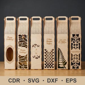 Puede incluir: Una colección de seis cajas de madera para botellas de vino con cortes decorativos y asas. Cada caja presenta diseños y textos únicos, incluyendo "Happy Birthday!", "Happy Holidays!" y "Congratulations!". Las cajas son de madera clara.